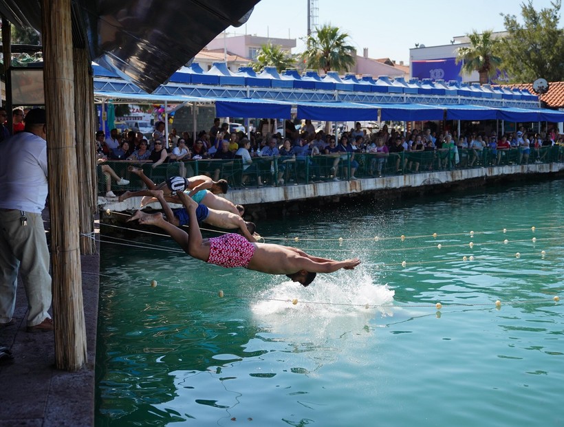 Ayvalık’ta Kabotaj Bayramı Coşkuyla Kutlandı Ayvalık’ta, 1 Temmuz Denizcilik ve Kabotaj Bayramı, çeşitli etkinliklerle coşkulu bir şekilde kutlandı. Ayvalık Belediye Başkanı Mesut Ergin’in katılımıyla gerçekleşen törenler, Cumhuriyet Meydanı’ndaki çelenk sunma programıyla başladı. Törenin ardından Başkan Ergin ve beraberindekiler, deniz şehitlerinin anısına Ayvalık’ın mavi sularına çelenk bırakarak saygı duruşunda bulundu. Etkinlikler kapsamında 100 metre yüzme yarışları ve geleneksel yağlı direkten bayrak alma yarışması da düzenlenerek renkli görüntüler ortaya çıktı. Kabotaj Bayramı’nın denizlerdeki bağımsızlığımızın sembolü olduğunu vurgulayan Başkan Ergin, “Ulu Önder Mustafa Kemal Atatürk’ün liderliğinde mavi sulardaki egemenliğimizi ilan ettiğimiz bu anlamlı günü, her yıl aynı inanç ve kararlılıkla kutlamaya devam edeceğiz. Atamızın ‘Topraklarının ucu deniz olan bir ulusun sınırını, halkının kudreti ve yeteneğinin hududu çizer’ sözünü rehber ediniyoruz. Denizcilik ve Kabotaj Bayramımız kutlu olsun” dedi. Kutlamalar, Ayvalık halkının yoğun katılımıyla bayram havasında tamamlandı.